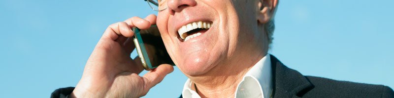 Hombre sonriendo y llamando por teléfono a la Clínica dental de Alcalá de Henares